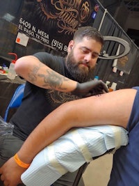 a man getting a tattoo at a convention