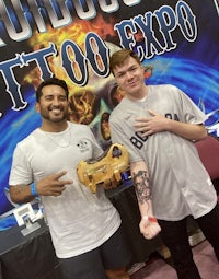 two men posing for a photo at the tattoo expo