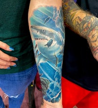 a tattoo of a shark on a person's arm